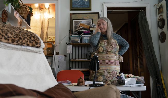 Nancy Rose, who contracted COVID-19 in 2021 and exhibits long-haul symptoms including brain fog and memory difficulties, pauses while organizing her desk space, Tuesday, Jan. 25, 2022, in Port Jefferson, N.Y. Rose, 67, said many of her symptoms waned after she got vaccinated, though she still has bouts of fatigue and memory loss. U.S. health officials estimate 3.3 million Americans have chronic fatigue syndrome — a bigger number than previous studies have suggested, and one likely boosted by patients with long COVID, according to results released by the Centers for Disease Control and Prevention on Friday, Dec. 8, 2023. (AP Photo/John Minchillo, File)