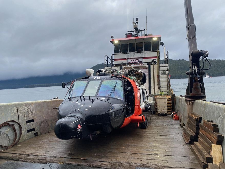 This image provided by the U.S. Coast Guard District 17 PADET Anchorage shows a U.S. Coast Guard MH-60 Jayhawk helicopter from Air Station Sitka on a boat after being recovered from the site of a crash near Read Island, Alaska, Friday, Dec. 8, 2023. The four crew members involved in the Nov. 13 crash survived. (Air Station Sitka/U.S. Coast Guard via AP)