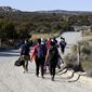Asylum-seekers walk to a U.S. Border Patrol van after crossing the nearby border with Mexico, Tuesday Sept. 26, 2023, near Jacumba Hot Springs, Calif. Migrants continue to arrive to desert campsites along California&#x27;s border with Mexico, as they await processing. (AP Photo/Denis Poroy, File)