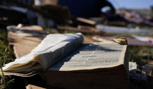 A Bible rests on the lawn of Community Baptist Church amongst storm debris Monday, Dec. 11, 2023, in Nashville, Tenn. The church was destroyed when severe storms came through over the weekend. Members of the church were trapped and injured inside the building during the storm on Saturday. (AP Photo/George Walker IV)