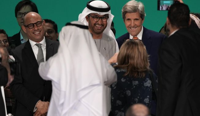 United Nations Climate Chief Simon Stiell, from left, COP28 President Sultan al-Jaber and John Kerry, U.S. Special Presidential Envoy for Climate, pose for photos at the end of the COP28 U.N. Climate Summit, Wednesday, Dec. 13, 2023, in Dubai, United Arab Emirates. (AP Photo/Kamran Jebreili)