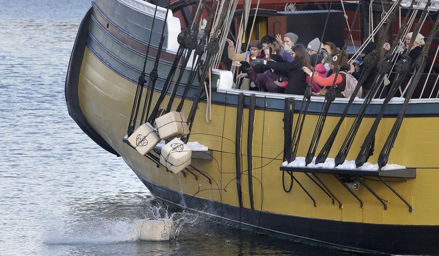 In this Monday, Dec. 11, 2017 photo, visitors to the Boston Tea Party Museum throw replicas of historic tea containers into Boston Harbor from aboard a replica of the vessel Beaver, in Boston. Patriotic mobs and harbor tea dumping are returning to Boston on Saturday, Dec. 16, 2023, as the city marks the 250th anniversary of the revolutionary protest that preceded America’s independence. (AP Photo/Steven Senne, files)