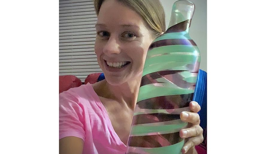 This image provided by Jessica Vincent shows Jessica Vincent holding a vase by Italian architect and designer Carlo Scarpa which was part of his Pennelatte series in the 1940s at her home in Henrico County, Virginia. Vincent purchased it at a Goodwill store outside Richmond, Va., in June for $3.99. It was sold through the Wright Auction House in Chicago on Wednesday Dec. 13, 2023, to a private European collector for $107,100. (Jessica Vincent via AP)