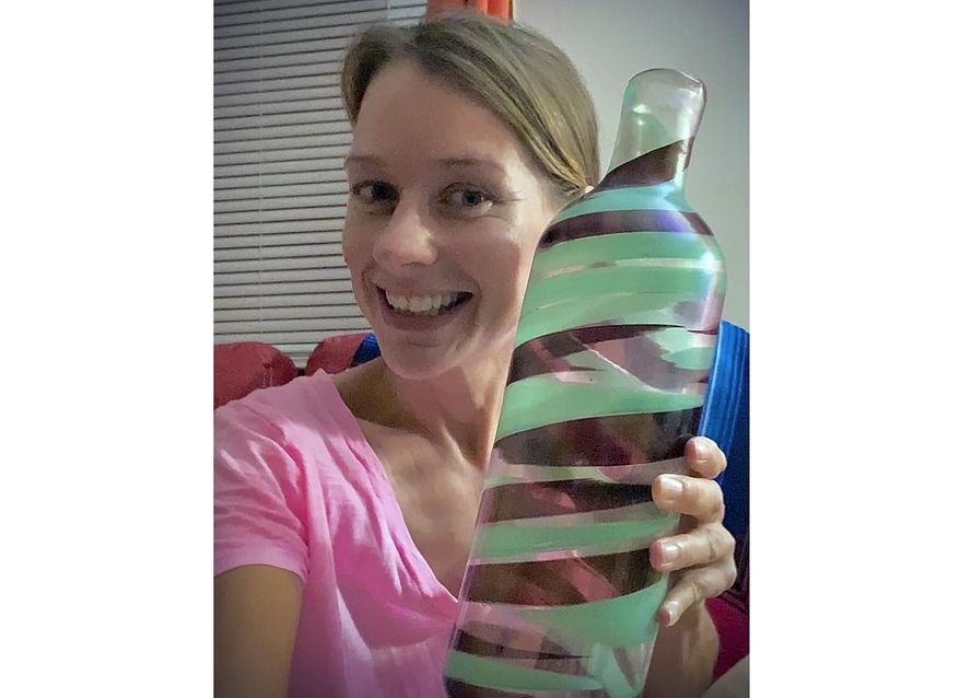 This image provided by Jessica Vincent shows Jessica Vincent holding a vase by Italian architect and designer Carlo Scarpa which was part of his Pennelatte series in the 1940s at her home in Henrico County, Virginia. Vincent purchased it at a Goodwill store outside Richmond, Va., in June for $3.99. It was sold through the Wright Auction House in Chicago on Wednesday Dec. 13, 2023, to a private European collector for $107,100. (Jessica Vincent via AP)