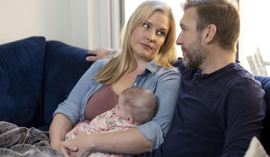 Kaitlyn Kash and husband Cory Kash sit at home with their 4-month-old daughter, Sunday, Dec. 17, 2023, in Austin, Texas. Kaitlyn Kash has joined as a plaintiff on the Zurawski v. State of Texas case, a lawsuit that looks to clarify the scope of the state&#x27;s abortion ban. (AP Photo/Stephen Spillman)