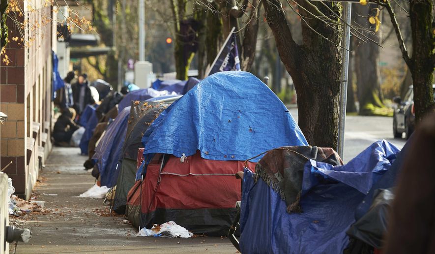 FILE - Tents line the sidewalk on SW Clay St in Portland, Ore., Dec. 9, 2020. According to an annual report released by regional officials Wednesday, Dec. 20, 2023, fentanyl and methamphetamine drove a record number of homeless deaths last year in Oregon&#x27;s Multnomah County, home to Portland. (AP Photo/Craig Mitchelldyer, File)