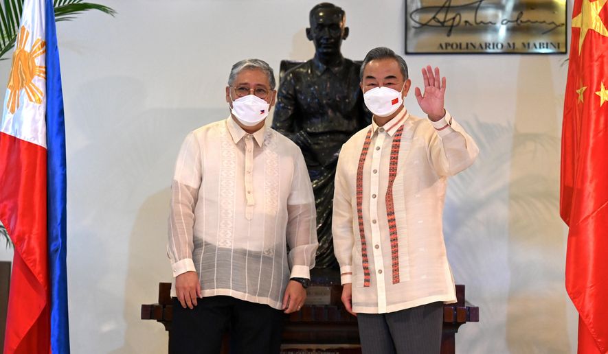 Philippine Foreign Affairs Secretary Enrique Manalo, left, and Chinese Foreign Minister Wang Yi pose for a photo before their bilateral talks at the Department of Foreign Affairs in Manila, Philippines on July 6, 2022. Wang Yi said on Wednesday, Dec. 20, 2023, the Asian power will maintain military pressure on the Philippines amid a dispute over sovereignty in the South China Sea that could involve U.S. forces defending their treaty partner. (Jam Sta Rosa/Pool Photo via AP, File)