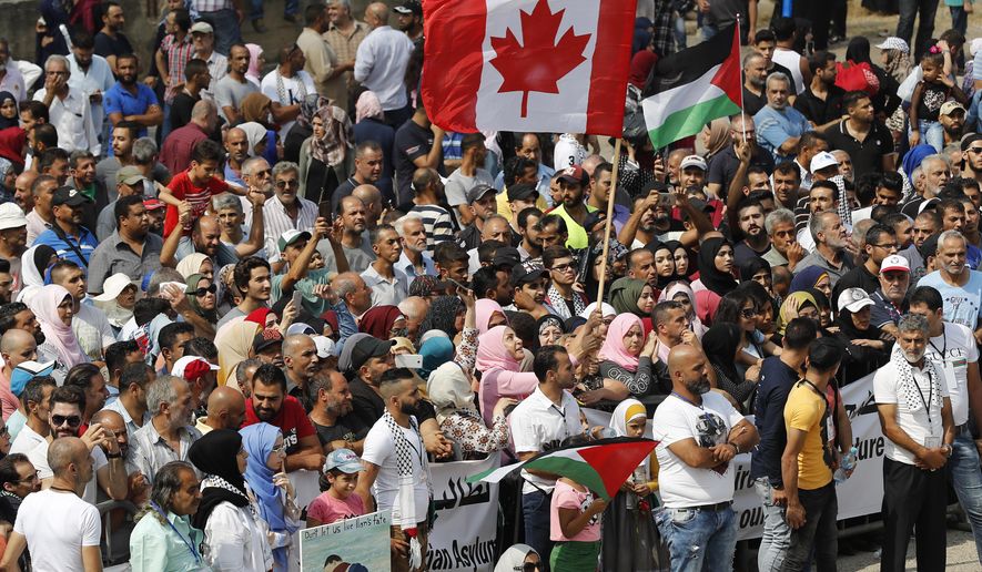 FILE - Hundreds of Palestinian refugees waving Palestinian and Canadian flags request asylum at a rally outside the the Canadian Embassy, in Beirut, Lebanon, Thursday, Sept. 5, 2019. People in the Gaza Strip who have Canadian relatives may apply for temporary visas to Canada, Canada’s immigration minister said Thursday, Dec. 21, 2023. However, the federal government cannot guarantee them safe passage out of the besieged Palestinian territory. Immigration Minister Marc Miller expects the program to be up and running by Jan. 9, 2024. (AP Photo/Hussein Malla, File)