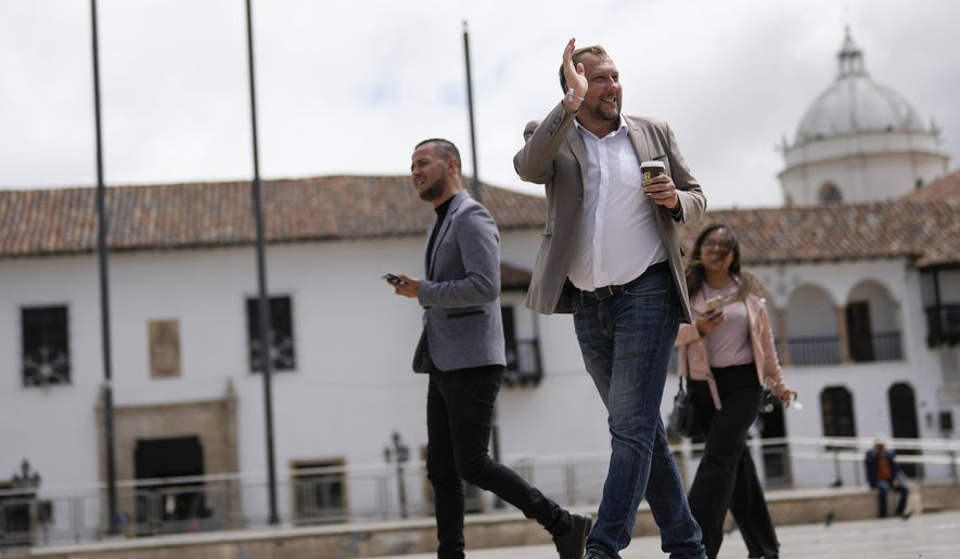Mayor-elect Mikhail Krasnov waves to a supporter as he walks through Bolivar Square in Tunja, Colombia, Monday, Dec. 11, 2023. Krasnov, a 45-year-old university professor from Russia, was one of the unexpected winners in Colombia’s regional elections in October. (AP Photo/Fernando Vergara)