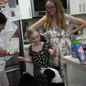 Sol, left, a 14-year-old from Argentina, and 8-year-old Maddie Hazelton joke around with some whipped cream as Sol&#x27;s foster mother, Caroline Hazelton, and the family&#x27;s two dogs look on, in Homestead, Fla., Monday, Dec. 18, 2023. Sol is among tens of thousands of children who have arrived in the United States without a parent during a huge surge in immigrants that&#x27;s prompting congressional debate to change asylum laws. (AP Photo/Rebecca Blackwell)