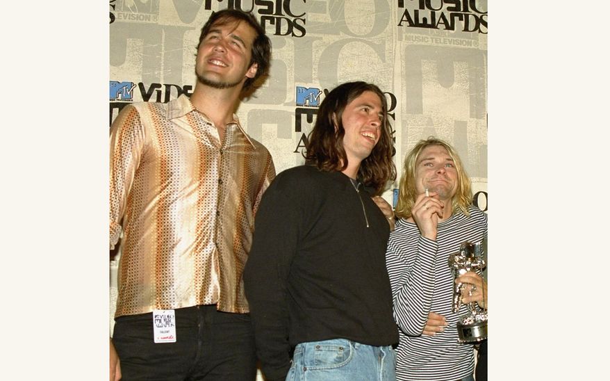 Nirvana band members Krist Novoselic, from left, Dave Grohl and Kurt Cobain pose after receiving the award for best alternative video for "In Bloom" at the 10th annual MTV Video Music Awards on Sept. 2, 1993, in Universal City, Calif. A federal appeals court has revived a child sexual exploitation lawsuit filed by the man who appeared naked as a 4-month-old infant on the 1991 cover of Nirvana's album "Nevermind." Spencer Elden's lawsuit against the grunge rock group was dismissed last year but a the court in California revived it on Thursday and sent it back to a lower court. (AP Photo/Mark J. Terrill, File)