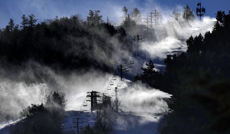 Man-made snow is blown from snowmaking equipment near the summit of Pleasant Mountain ski resort, Thursday, Dec. 21, 2023, in Bridgton, Maine. The New England ski industry is working to recover from a disastrous rainstorm that washed away much of the snow just before the Christmas vacation season. (AP Photo/Robert F. Bukaty)