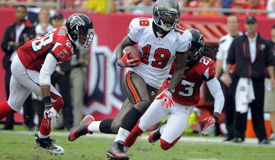 Tampa Bay Buccaneers wide receiver Mike Williams (19) finds room to run between Atlanta Falcons free safety Thomas DeCoud (28) and cornerback Dunta Robinson (23) during an NFL football game Sunday, Sept. 25, 2011, in Tampa, Fla. Williams died from a rare form of sepsis infection related to dental health problems, according to a medical examiner’s report, Friday, Dec. 22, 2023. Williams, 36, died Sept. 12 after he was initially hospitalized following a construction accident while working as an electrician. (AP Photo/Brian Blanco, File)