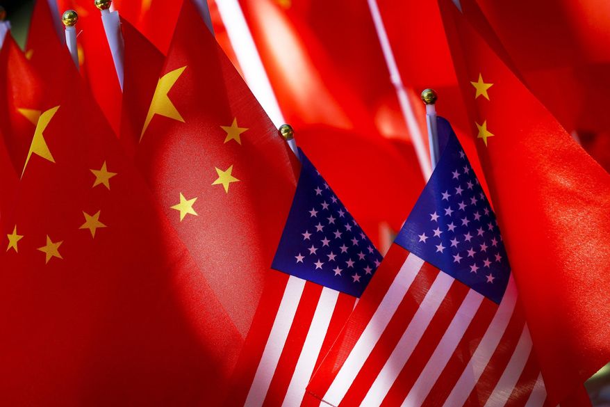 American flags are displayed together with Chinese flags on top of a trishaw on Sept. 16, 2018, in Beijing. (AP Photo/Andy Wong, File)