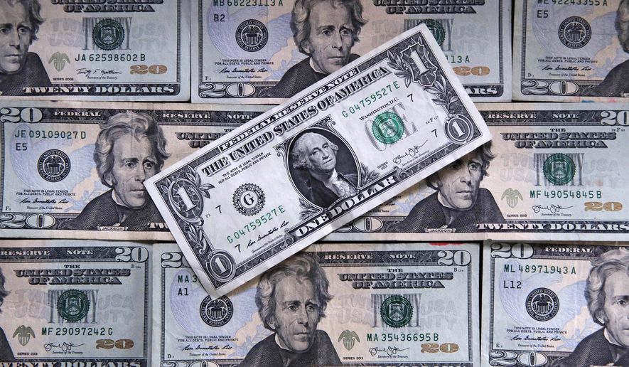 This June 15, 2018, file photo shows U.S. currency on a counter in East Derry, N.H.  (AP Photo/Charles Krupa, File)