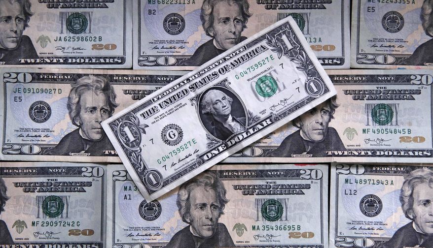 This June 15, 2018, file photo shows U.S. currency on a counter in East Derry, N.H. (AP Photo/Charles Krupa, File)