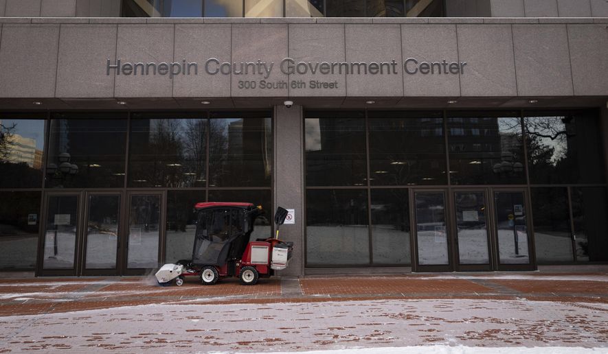 Snow is removed from the entrance of the Hennepin County Government Center in Minneapolis on Wednesday, Dec. 8, 2021. A Minnesota woman has sued her dentist after receiving four root canals, eight dental crowns and 20 fillings in a single visit that she says led to her disfigurement. Kathleen Wilson filed the lawsuit last week in Hennepin County District Court. (AP Photo/Christian Monterrosa, File)