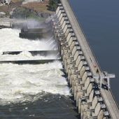 Water flows through the Dalles Dam in the Columbia River, in Dalles, Ore, on June 3, 2011. Restoring salmon and steelhead populations is expensive because they’re widespread and hemmed in by massive hydroelectric dams. (AP Photo/Rick Bowmer, File)
