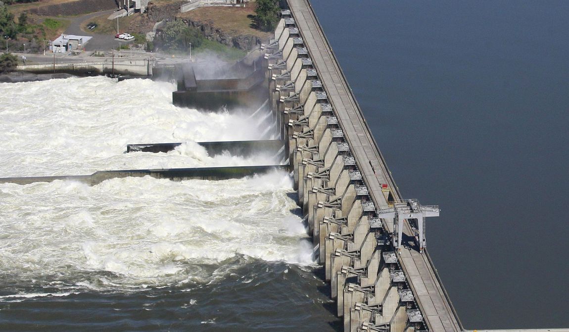 Water flows through the Dalles Dam in the Columbia River, in Dalles, Ore, on June 3, 2011. Restoring salmon and steelhead populations is expensive because they’re widespread and hemmed in by massive hydroelectric dams. (AP Photo/Rick Bowmer, File)