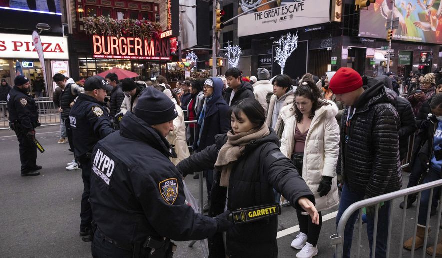 NYPD officers check people ahead of the New Year's Eve in Times Square celebration, Sunday, Dec. 31, 2023, in New York. (AP Photo/Yuki Iwamura)