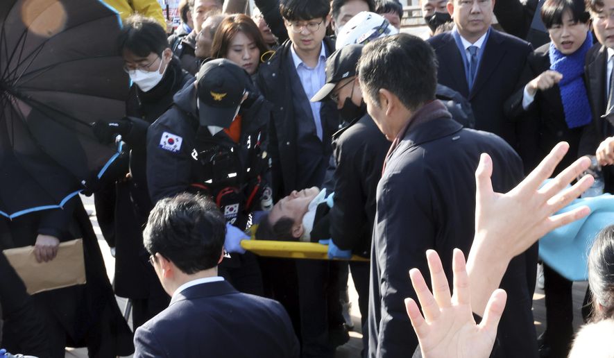 South Korean opposition leader Lee Jae-myung on a stretcher, is carried by rescue team in Busan, South Korea, Tuesday, Jan. 2, 2024. Lee was attacked and injured by an unidentified man during a visit Tuesday to the southeastern city of Busan, emergency officials said. (Ha Kyung-min/Newsis via AP)