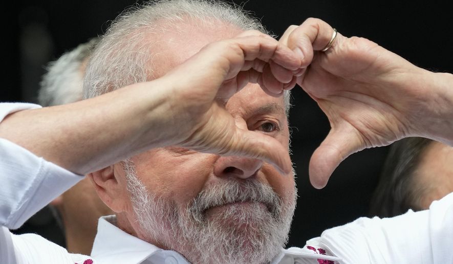 Brazilian President Luiz Inacio Lula da Silva flashes a heart-hand sign at supporters during a rally in Sao Paulo, Brazil, May 1, 2023. Lula likes to boast he had a good first year returning to the job. The economy is improving, Congress passed a long-overdue tax reform package, rioters who wanted to oust him are now in jail and his predecessor and foe Jair Bolsonaro is barred from running for office until 2030. (AP Photo/Andre Penner, File)
