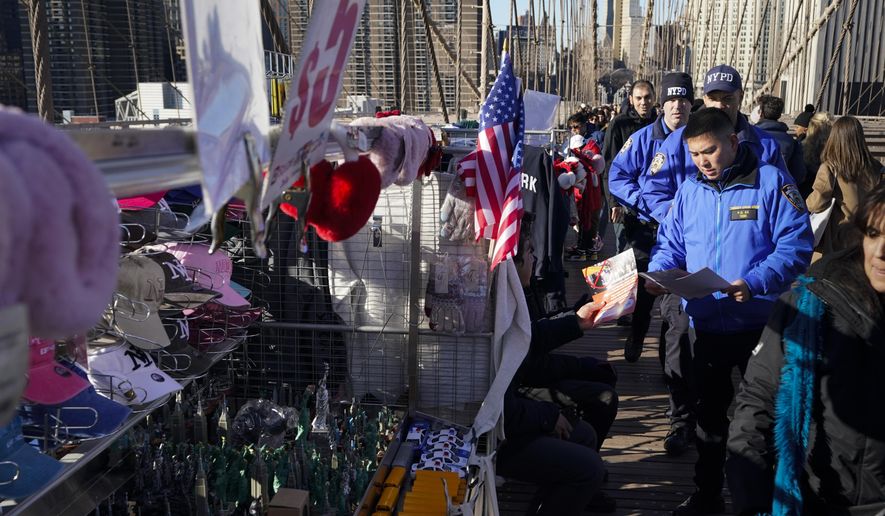 Police officers had out notices to vendors on the Brooklyn Bridge in New York, Tuesday, Jan. 2, 2024. The notices warn vendors that no more vending will be allowed on the bridge starting January 3, 2024. (AP Photo/Seth Wenig)