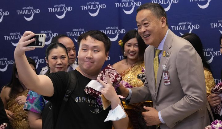 Chinese tourists takes selfies with Thailand&#x27;s Prime Minister Srettha Thavisin, right, at Suvarnabhumi International Airport in Samut Prakarn province, Thailand, Monday, Sept. 25, 2023. (AP Photo/Sakchai Lalit, File)