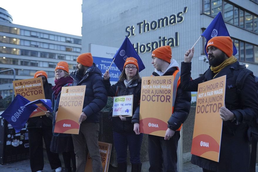 Junior doctors and members of the British Medical Association (BMA) demonstrate outside St. Thomas' Hospital, London, Wednesday, Jan. 3, 2024, as they take to picket lines for six days. Doctors in the early stages of their careers in England have started a 72-hour strike in their long-running dispute over pay levels. (Jonathan Brady/PA via AP)