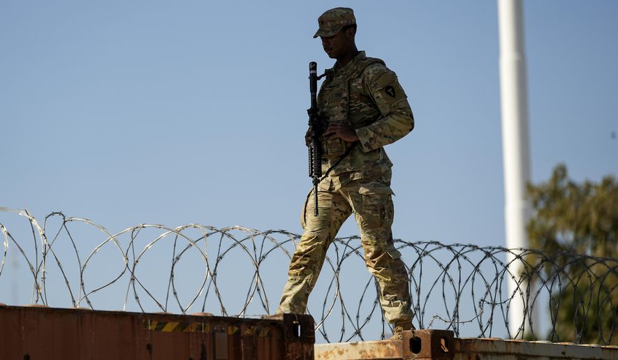 A guardsman walks over rail cars with Concertina wire along the Texas-Mexico border, Wednesday, Jan. 3, 2024, in Eagle Pass, Texas. U.S. House Speaker Mike Johnson is leading about 60 fellow Republicans in Congress on a visit to the Mexican border. Their trip comes as they are demanding hard-line immigration policies in exchange for backing President Joe Biden's emergency wartime funding request for Ukraine. (AP Photo/Eric Gay)