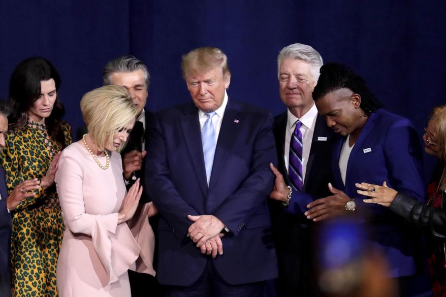 Pastor Paula White, left, and other faith leaders pray with President Donald Trump, center, during a rally for evangelical supporters at the King Jesus International Ministry church, Friday, Jan. 3, 2020, in Miami. (AP Photo/Lynne Sladky, File)