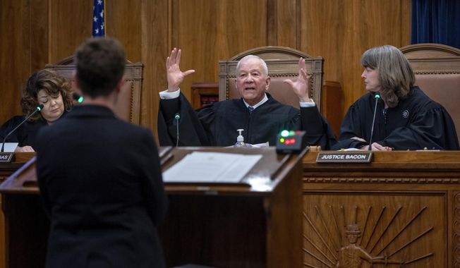 New Mexico Supreme Court Chief Justice Michael Vigil, center, along with Justice Julie Vargas, left, and Chief Justice Shannon Bacon question attorney Holly Agajanian, the governor&#x27;s chief general counsel, during oral arguments over the challenge to Gov. Michelle Lujan Grisham&#x27;s executive order prohibiting the carrying firearms in Albuquerque parks and playgrounds, as the justices hear both sides during a Supreme Court hearing, in Santa Fe, N.M., Monday, Jan. 8, 2024. (Eddie Moore/The Albuquerque Journal via AP)