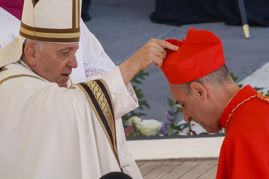 Newly elected Cardinal Víctor Manuel Fernández, Prefect of the Dicastery for the Doctrine of the Faith, right, receives his biretta from Pope Francis as he is elevated in St. Peter's Square at The Vatican, Saturday, Sept. 30, 2023. The Vatican’s new doctrine chief, already under fire from entire bishops conferences for his approval of blessings for same-sex couples, is raising eyebrows anew over a book he wrote as a young priest describing orgasms in graphic terms. (AP Photo/Riccardo De Luca, File)