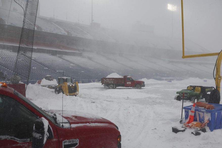 Workers remove snow from Highmark Stadium in Orchard Park, N.Y., Sunday Jan. 14, 2024. A potentially dangerous snowstorm that hit the Buffalo region on Saturday led the NFL to push back the Bills wild-card playoff game against the Pittsburgh Steelers from Sunday to Monday. New York Gov. Kathy Hochul and the NFL cited public safety concerns for the postponement, with up to 2 feet of snow projected to fall on the region over a 24- plus hour period. (AP Photo/ Jeffrey T. Barnes)