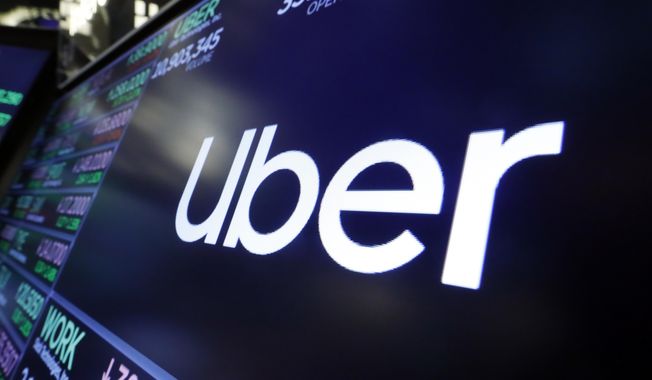FILE - The logo for Uber appears above a trading post on the floor of the New York Stock Exchange, Aug. 16, 2019. Uber is shutting down alcohol delivery app Drizly, the company confirmed this week, just under three years after acquiring the platform for $1.1 billion. Drizly will officially shut down at the end of March, Uber told The Associated Press. (AP Photo/Richard Drew, File)