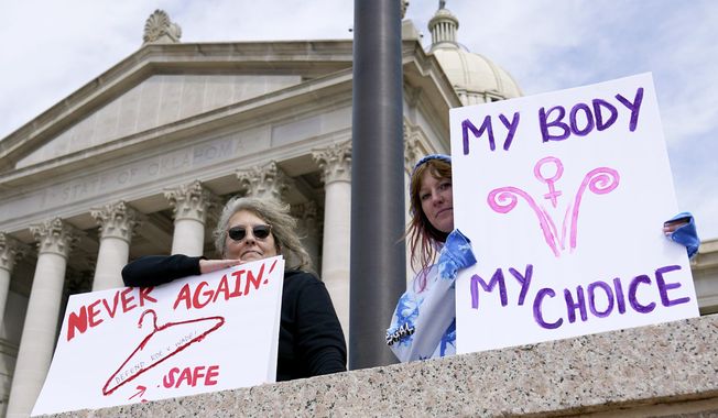 Dani Thayer, left, and Marina Lanae, right, both of Tulsa, Okla., hold pro-choice signs outside the state Capitol, Wednesday, April 13, 2022, in Oklahoma City. The U.S. Department of Health and Human Services said Friday, Jan 19, 2024, an Oklahoma hospital did not violate federal law when doctors told a woman with a nonviable pregnancy to wait in the parking lot until her condition worsened enough to qualify for an abortion under the state&#x27;s strict ban. (AP Photo/Sue Ogrocki) **FILE**