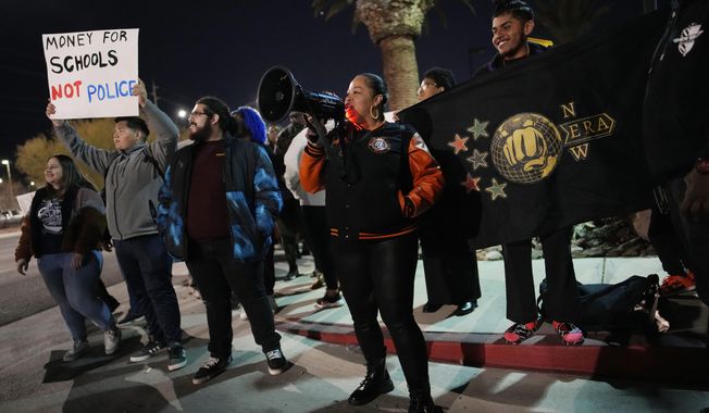 Karena Graham, center, president of New Era Las Vegas, leads a chant during a protest against police violence Friday, Feb. 17, 2023, in Las Vegas. School officials in Las Vegas have released police reports and body camera footage of a white campus police officer kneeling on a Black student who had been recording officers a year ago in a scene that was captured on cellphone video and widely shared on social media. (AP Photo/John Locher, FILE)