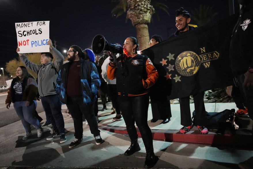 Karena Graham, center, president of New Era Las Vegas, leads a chant during a protest against police violence Friday, Feb. 17, 2023, in Las Vegas. School officials in Las Vegas have released police reports and body camera footage of a white campus police officer kneeling on a Black student who had been recording officers a year ago in a scene that was captured on cellphone video and widely shared on social media. (AP Photo/John Locher, FILE)
