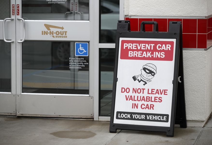 A sign warns patrons of car break-ins at the In-N-Out restaurant off Hegenberger Road in Oakland, Calif., on Monday, Jan. 22, 2024. In-N-Out will close its only restaurant in Oakland because of a wave of car break-ins, property damage, theft and armed robberies targeting customers and employees alike, the company announced. The burger joint in a busy corridor near the Oakland International Airport will close on March 24, 2024. (Jane Tyska/Bay Area News Group via AP)
