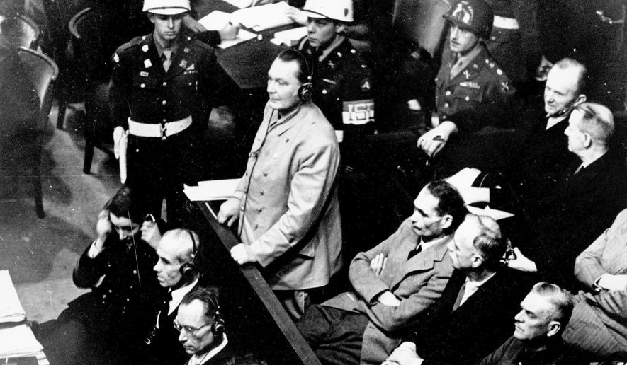 In this Nov. 21, 1945, file photo, Reichsmarshal Hermann Goering stands in the prisoner's dock at the Nuremberg War Crimes Trial in Germany. He is entering a plea of not guilty to the International Military Tribunal Indictment. Goering is wearing headphones of the court translating system. Germany marks the 75th anniversary of the landmark Nuremberg trials of several Nazi leaders and in what is now seen as the birthplace of a new era of international law on Friday, Nov. 20, 2020. (AP Photo) **FILE**