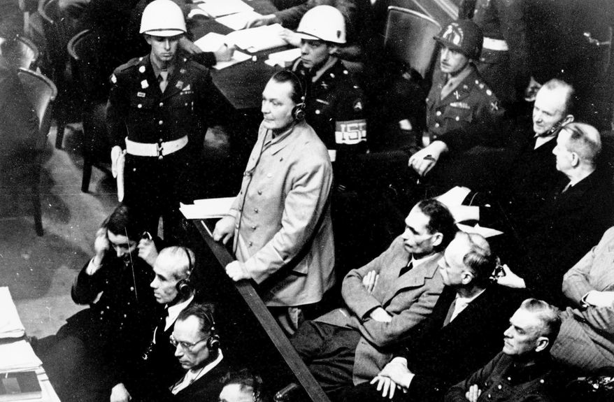 In this Nov. 21, 1945, file photo, Reichsmarshal Hermann Goering stands in the prisoner's dock at the Nuremberg War Crimes Trial in Germany. He is entering a plea of not guilty to the International Military Tribunal Indictment. Goering is wearing headphones of the court translating system. Germany marks the 75th anniversary of the landmark Nuremberg trials of several Nazi leaders and in what is now seen as the birthplace of a new era of international law on Friday, Nov. 20, 2020. (AP Photo) **FILE**