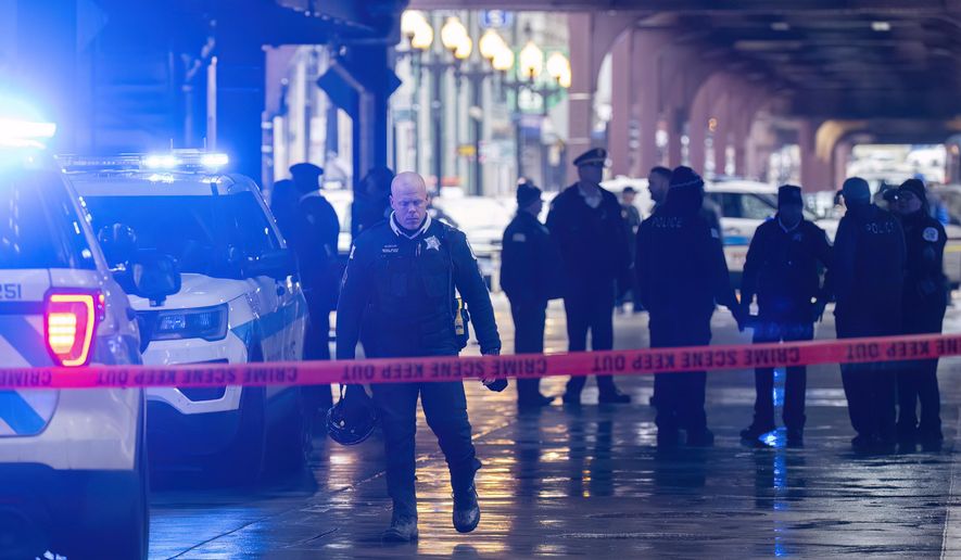Chicago police work the scene where two high school students were shot and killed just blocks from Millennium Park, in Chicago, Friday, Jan. 26, 2024. (Tyler Pasciak LaRiviere/Chicago Sun-Times via AP)