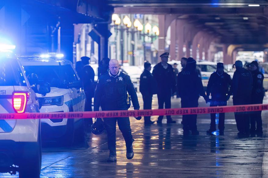 Chicago police work the scene where two high school students were shot and killed just blocks from Millennium Park, in Chicago, Friday, Jan. 26, 2024. (Tyler Pasciak LaRiviere/Chicago Sun-Times via AP)