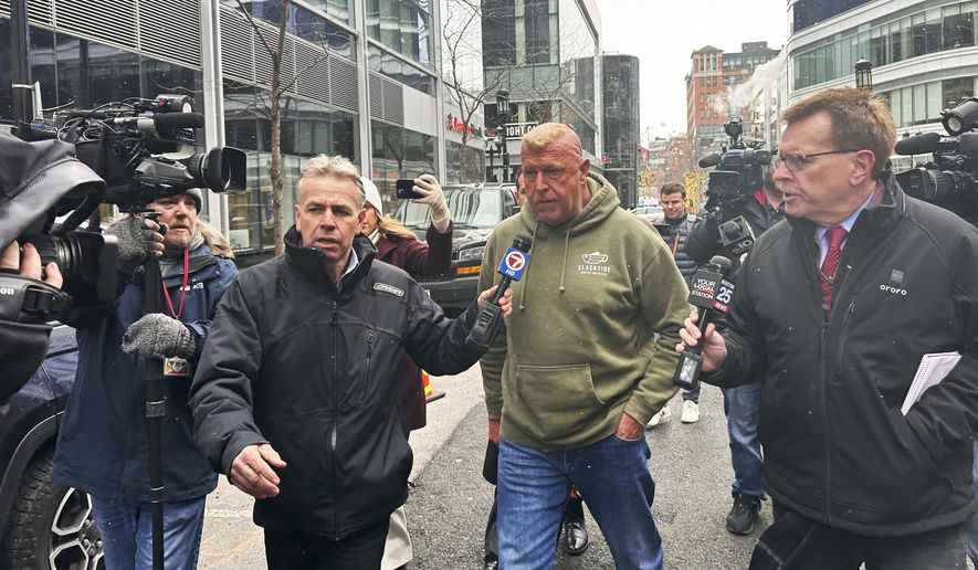 Massachusetts State Police Sgt. Gary Cederquist, center, leaves federal court. Tuesday, Jan 30, 2024, in Boston. Cederquist, 58, of Stoughton, and five others have been charged Tuesday in a scheme to allegedly take bribes including a new snowblower and driveway in exchange for giving passing scores on commercial driving tests, the U.S. attorney’s office said Tuesday. (AP Photo/Michael Casey)