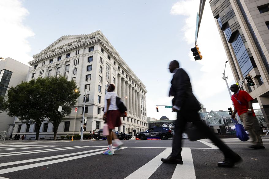 People cross the street near the Fulton County Courthouse, Aug. 14, 2023, in Atlanta. Court and other systems in Fulton County, Georgia's most populous county, were hacked over the weekend, resulting in interruptions to routine operations, officials said Monday, Jan. 29, 2024, adding that the racketeering case against former President Donald Trump is unaffected. (AP Photo/Alex Slitz, File)