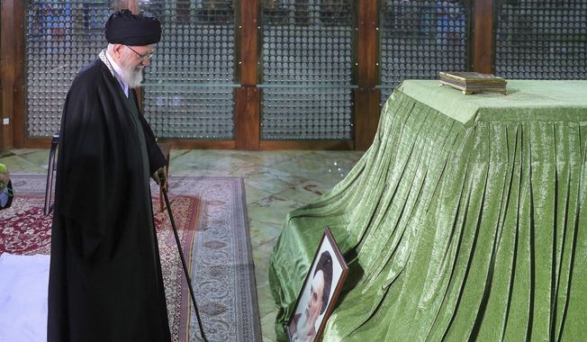 In this photo released by the office of the Iranian supreme leader, Supreme Leader Ayatollah Ali Khamenei prays at the grave of the late revolutionary founder Ayatollah Khomeini, just outside Tehran, Iran, Wednesday, Jan. 31, 2024. (Office of the Iranian Supreme Leader via AP)