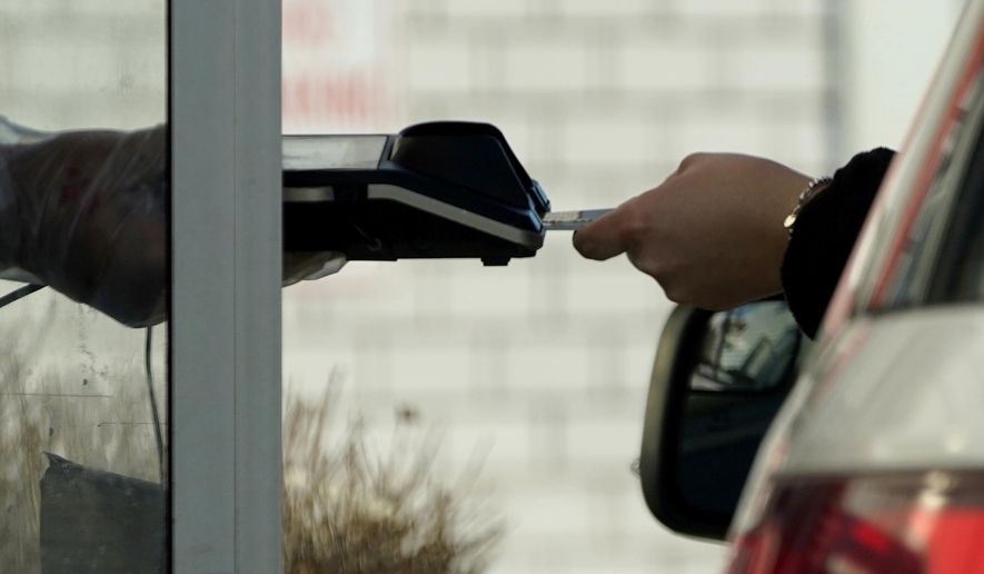 A card reader is used at a drive-thru restaurant in Mount Prospect, Ill., March 13, 2021. Noticeable pockets of Americans are quickly running up their credit card balances and increasing numbers are now falling behind on their debts. (AP Photo/Nam Y. Huh) **FILE**