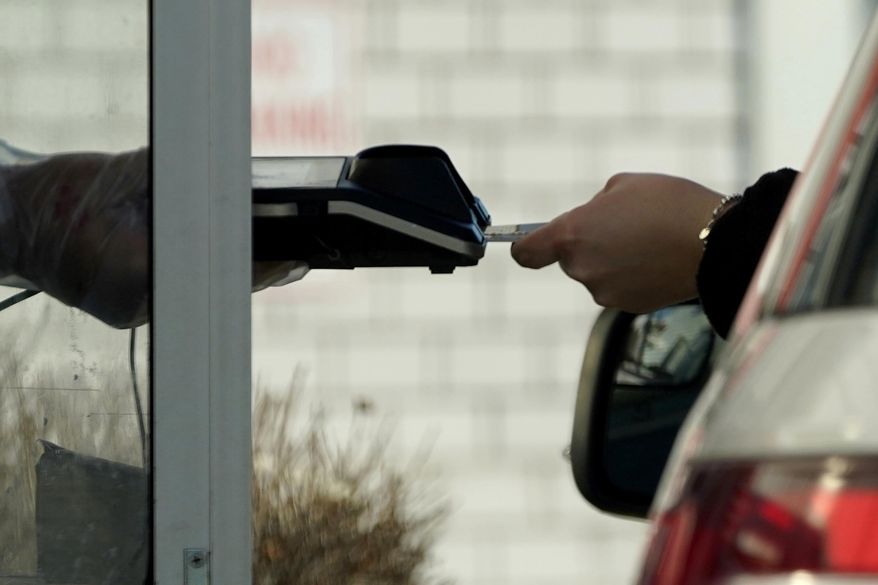 A card reader is used at a drive-thru restaurant in Mount Prospect, Ill., March 13, 2021. Noticeable pockets of Americans are quickly running up their credit card balances and increasing numbers are now falling behind on their debts. (AP Photo/Nam Y. Huh) **FILE**