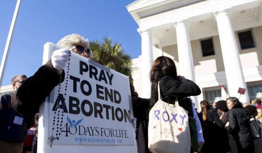 An pro-life protester holds a sign while standing outside the Florida Supreme Court after the Court heard arguments on the proposed abortion amendment Wednesday, Feb. 7, 2024 in Tallahassee, Fla. (Alicia Devine/Tallahassee Democrat via AP)