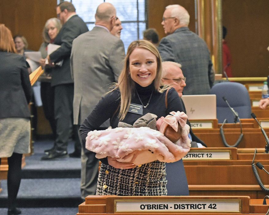 FILE - Rep. Emily O'Brien R-Grand Forks carries daughter Jolene Green, 3 weeks, into the House chamber, Dec. 6, 2022, in Bismarck, N.D. Last year, the state representative helped persuade her colleagues to approve $66 million in child care spending proposed by Gov. Doug Burnum, a Republican. O'Brien argued it could help the state's workforce shortage by helping more parents go to work. (Tom Stromme/The Bismarck Tribune via AP)